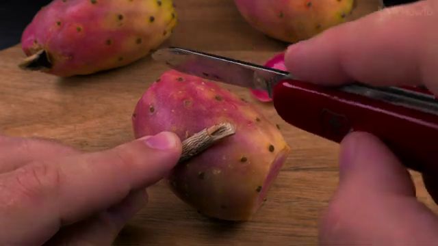 Slicing cactus fruit skin lengthwise with pocket knife
