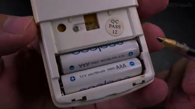Sliding open the battery cover on an AC remote control
